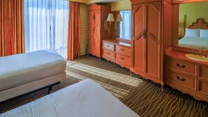 Una habitación de hotel con cama, cómoda, espejo y ventana con cortinas.