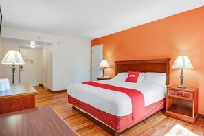 Ein Hotelzimmer mit einem Bett, Nachttischen, Lampen und Holzboden.