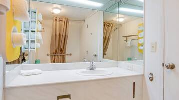 Un baño con un espejo grande, lavamanos blanco y barra para toallas.