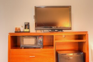 A kitchenette with a microwave, coffee maker, and a small refrigerator.