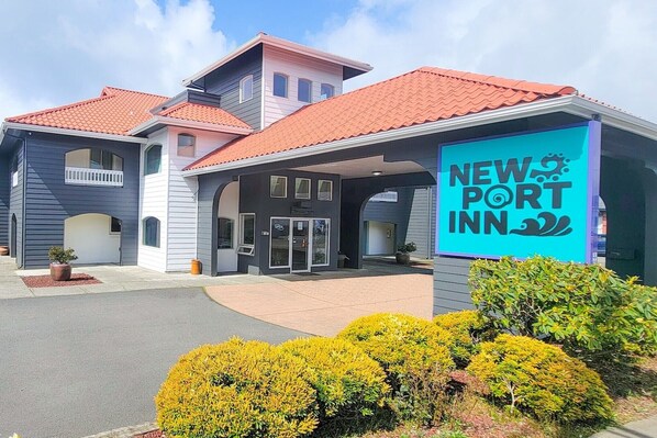 A New Port Inn building with a red-tiled roof, a covered entrance, and a signboard.