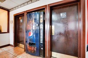 A hallway with a vending machine, a women's restroom, and a men's restroom.
