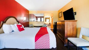 A hotel room with a bed, a TV, a desk, and a chair.
