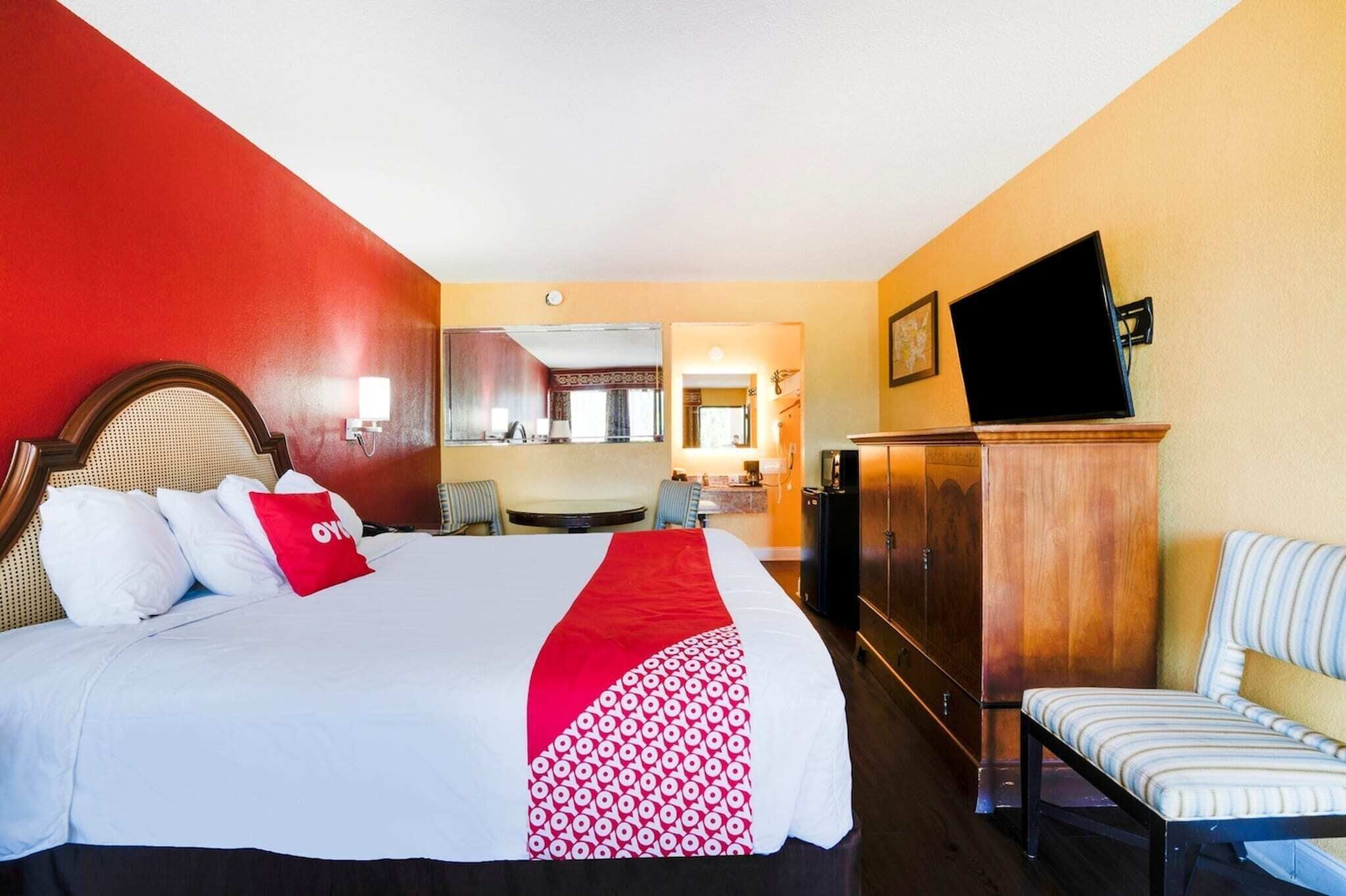 Una habitación de hotel con cama, televisión, escritorio y silla.