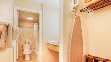 Ein Badezimmer mit Toilette, einem Waschbecken mit Handtuchhalter und einer Duschvorhang.