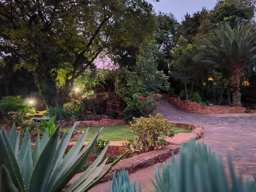 A landscaped garden with a variety of plants and a stone pathway.
