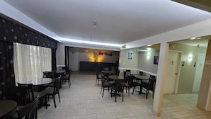 En hotellobby med flera sittgrupper, en receptionsdisk och ett klinkergolv.