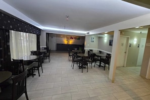 Un vestíbul d'hotel amb diverses zones d'estar, una recepció i un terra d'arrebossat.