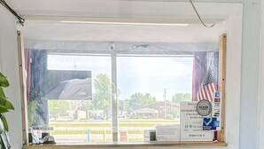 A window with a view of a parking lot, a building, and a sign with 'Welcome' and 'Hickory Check-in' text.