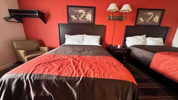 A hotel room with two beds, a chair, and two wall-mounted lamps.