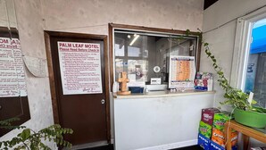 A motel with a check-in counter, a door with a sign, and vending machines. - 3 Full Beds Non-Smoking (Ashland, VA)