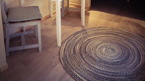 Ett mysigt rum med en säng, ett bord, en stol och en lampa.
