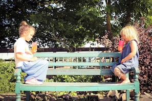To personer sidder på en bænk i en park.