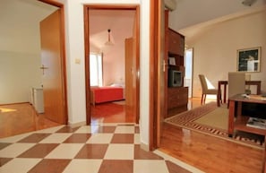 A room with a checkered floor, a bed, a desk, and a chair. - Apartman Nada (Cavtat)