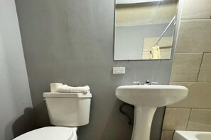 Ein Badezimmer mit Toilette, Waschbecken und Spiegel.