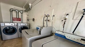 Un'area lavanderia con due lavatrici, un'asciugatrice e uno scaldabagno.