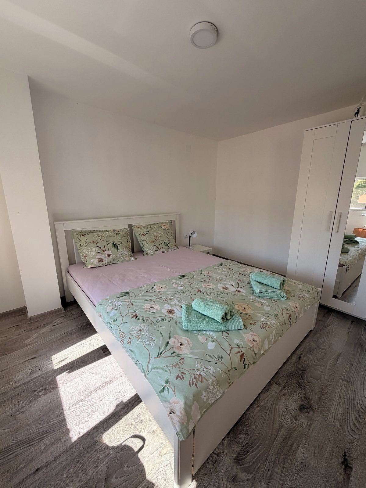 Quarto com cama, guarda-roupa e iluminação no teto.