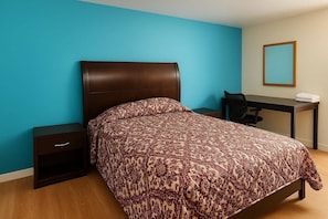 Un dormitorio con una cama, un escritorio y una silla.