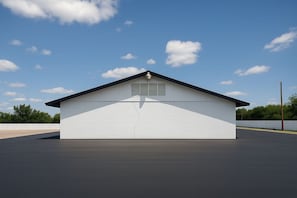 A single-story building with a flat roof, a central vent, and a small window.