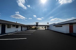 A building with a central entrance, multiple rooms on either side, and a clear sky.