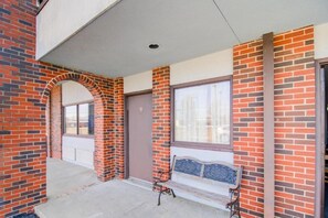 A building with a brick facade, a covered entrance, and a bench outside.