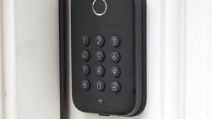 A black numeric keypad lock on a door.