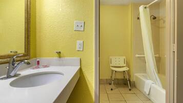 A bathroom with a white sink, mirror, and shower curtain.