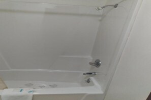Una banyera blanca amb test de dutxa i aixeta.