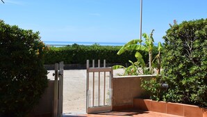 Une porte ouverte donne accès à un patio d’où l’on peut admirer l’océan.