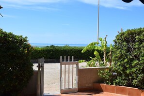 An open gate leading to a patio area with a view of the ocean. - Vacation Home in Marina Di Ragusa with 3 bedrooms sleeps 6 (Marina Di Ragusa)
