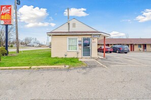 A small motel with a single office, a parking lot, and a sign for a nearby restaurant.