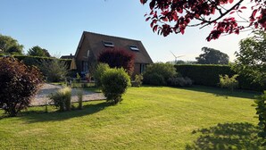 A house with a sloped roof, a gravel driveway, and a well-maintained lawn. - Chalet between land and sea (Ambrumesnil)