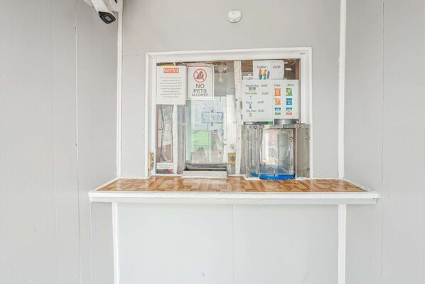 A vending machine with a sign indicating no pets allowed, a notice about a 10% discount for cash payments, and a price list for various items.
