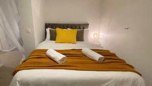 A hotel room with a bed, a headboard, a bedside table, and a lamp. - Pet Friendly Urban Escape in Antwerp (Antwerp)