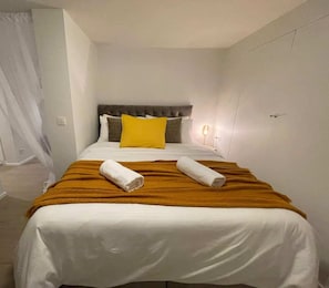 A hotel room with a bed, a headboard, a bedside table, and a lamp. - Pet Friendly Urban Escape in Antwerp (Antwerp)