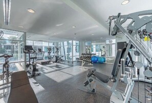 Ein modernes Fitnessstudio mit vielfältigen Trainingsgeräten, großen Fenstern und einer großzügigen Gestaltung.