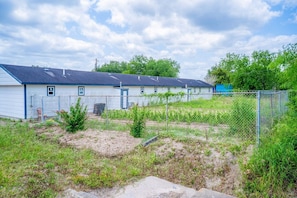 A row of single-story buildings with a chain-link fence in front.
