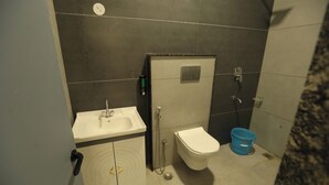 Un baño con lavamanos, inodoro y ducha.