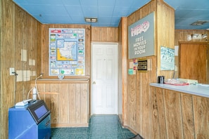 A reception area with a wooden interior, a map on the wall, a sign offering free movies, and a blue machine.