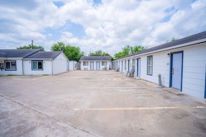 A row of motel rooms with a central parking area.