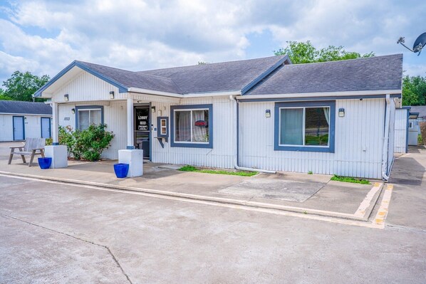 A single-story motel with a front door, a small porch, and a visible garage door.