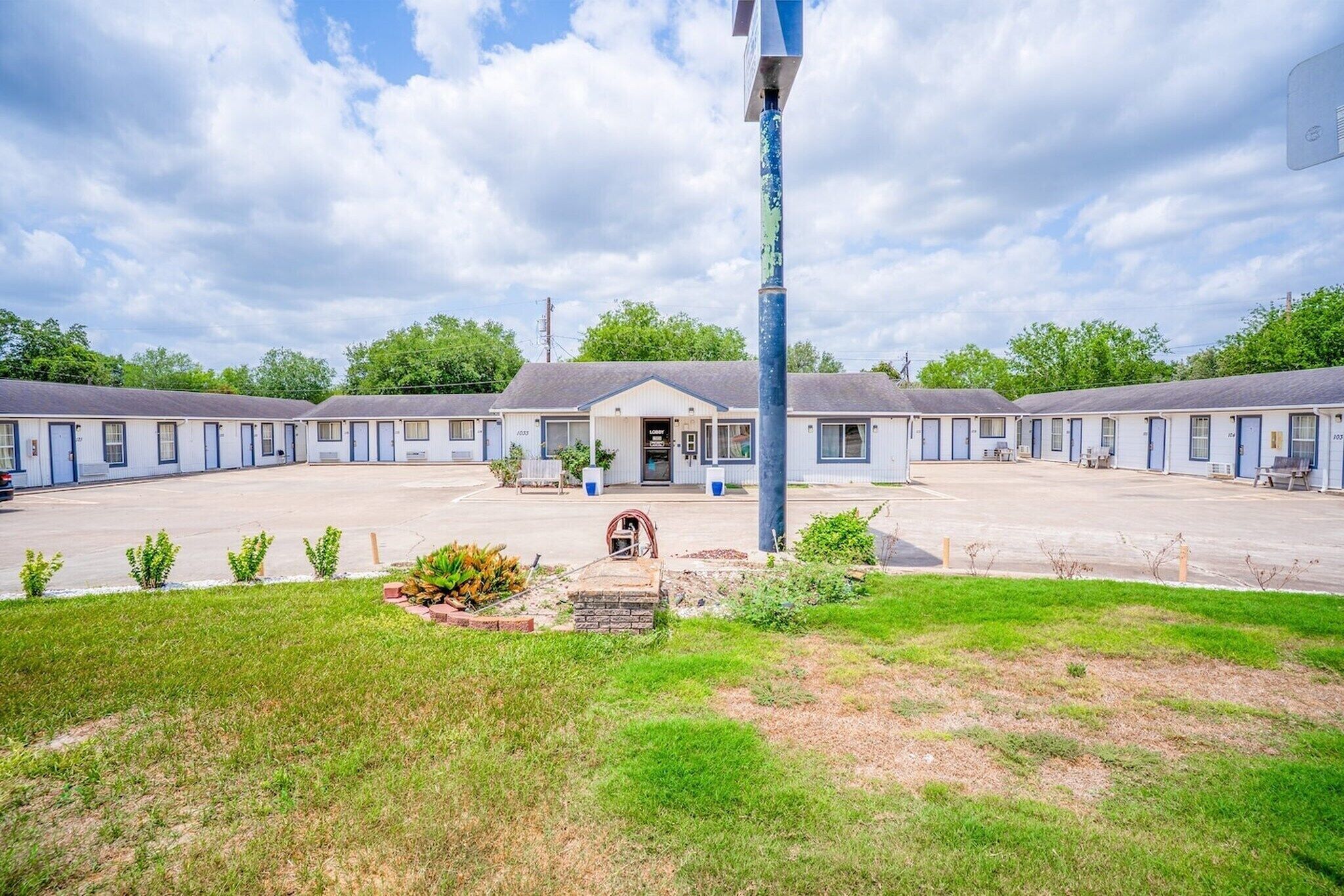 Un motel con un edificio central y varias unidades adosadas.