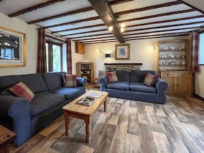 A cozy living room with two sofas, a coffee table, and a bookshelf. - Brambles Cottage - UK51981 (Little Torrington)