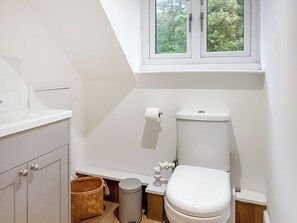 A modern bathroom with a toilet, bidet, and a window with a view of trees. - 3 bedroom accommodation in Goudhurst, near Cranbrook (Goudhurst, near Cranbrook)