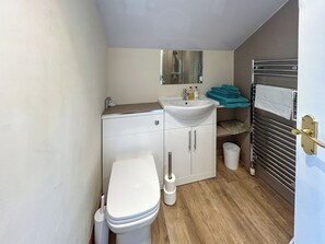 Ein kleines Badezimmer mit Toilette, Waschbecken und Spiegel.