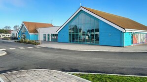 A modern building with large windows and a sloped roof. - 2 bedroom accommodation in Hayling Island (Hayling Island)