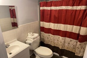 A bathroom with a toilet, sink, and a shower curtain. - 2 Queen Beds Suite with Kitchenette (Englewood CO)