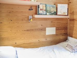 A wooden wall with a shelf holding books, a small clock, and a vent. - 3 bedroom accommodation in Cenarth (Cenarth)