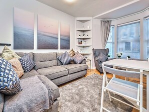 A modern living room with a grey sofa, patterned cushions, a white coffee table, and a bookshelf. - No.2 Princess Yellow Apartments - UK52053 (Portrush)