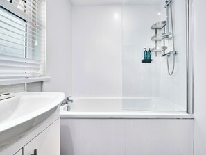 A modern bathroom with a white sink, a bathtub, and a glass-enclosed shower area. - No.3 Princess Yellow Apartments - UK52054 (Portrush)